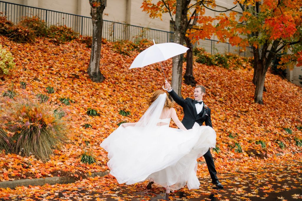 Bride and groom under umbrella at rainy fall wedding in Louisville KY