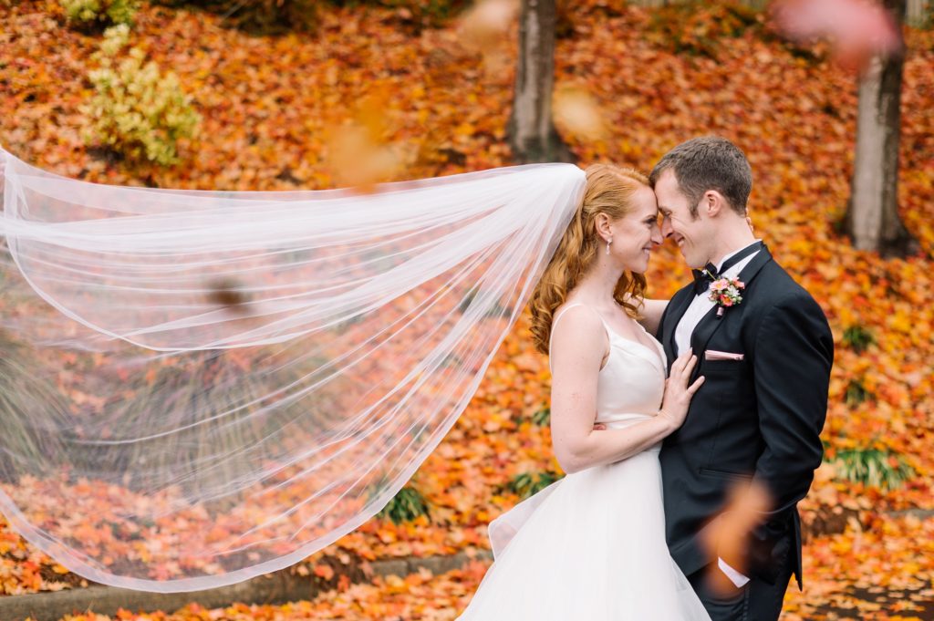 Bride and Groom with colorful fall leaves at rainy wedding in Louisville KY